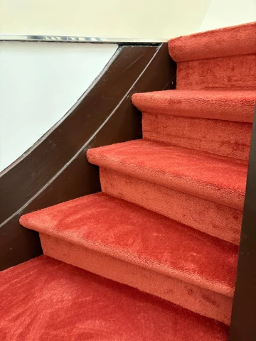 Habillage d'un escalier en tapis rouge à Schaerbeek